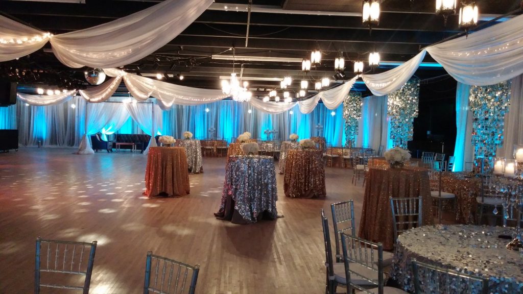 social events ballroom with draping, sequin table covers and lighting