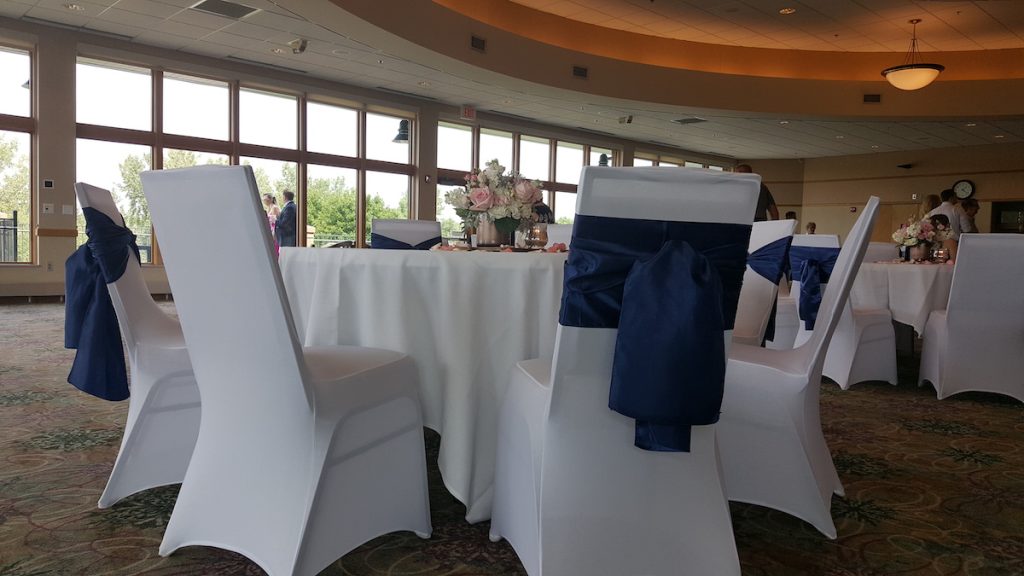 white covered chairs with blue sash